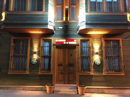 um edifício com portas e janelas de madeira à noite em Green Mansion em Istambul