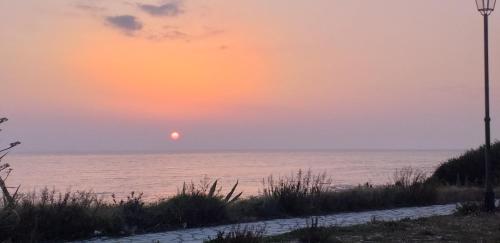 a sunset over the ocean with a street light at NICOL APARTMENS in Preveza