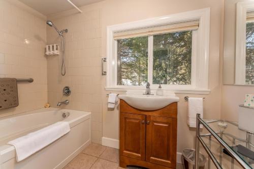 a bathroom with a sink and a tub and a window at Big Creek Inn in Fish Camp