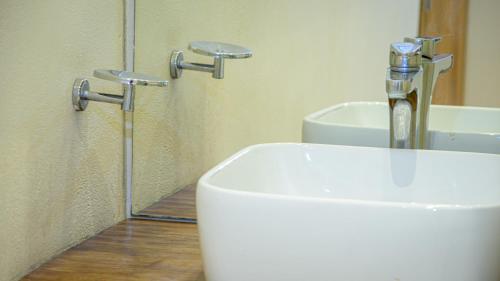a white toilet in a bathroom with a mirror at Moonshine Tulum Hotel & Hostel in Tulum