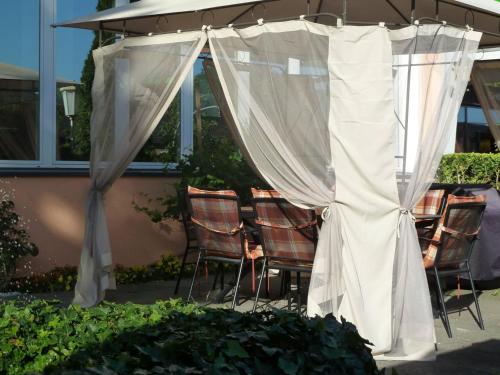 a patio with chairs and a white curtain at Hotel Hanseat Hamburg in Hamburg