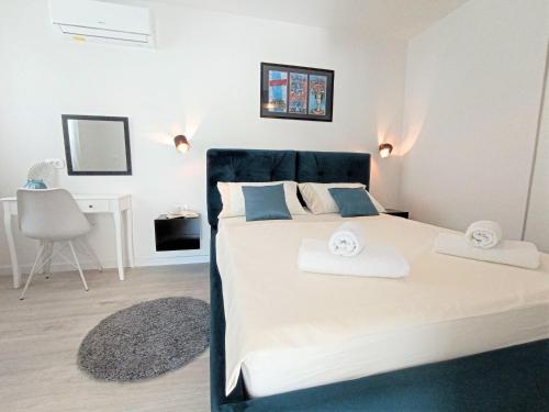 a bedroom with a large bed with two towels on it at Apartments Mirko in Mimice