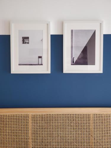 two framed photographs on a blue wall at La porticina. Your lake view home. in Barrea