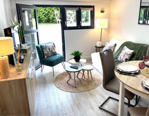 a living room with a table and chairs at GITE L'Orée Deauvillaise 5 minutes DeauvilleTrouville in Bonneville-sur-Touques