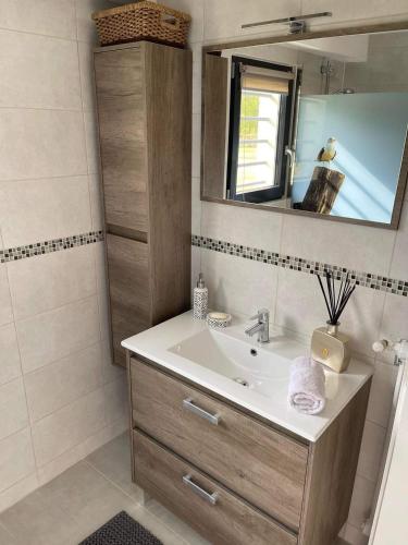 une salle de bain avec un lavabo et un miroir dans l'établissement GITE L'Orée Deauvillaise 5 minutes DeauvilleTrouville, à Bonneville-sur-Touques