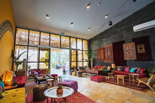 a living room with colorful furniture and large windows at Selina Desert Garden Ramon in Mitzpe Ramon