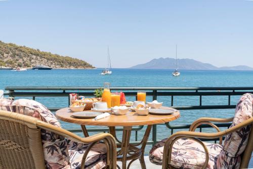 a table with food on a balcony with the ocean at Binji Hotel in Ancient Epidavros