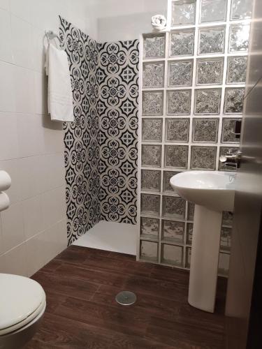 a bathroom with a sink and a shower curtain at Hostal Andalucía in Chipiona
