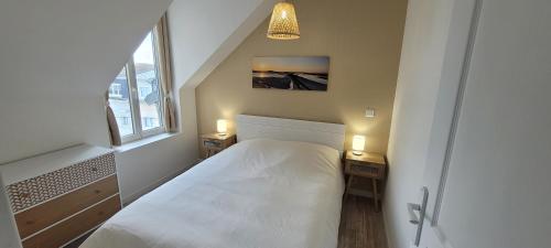 een kleine slaapkamer met een bed en twee nachtkastjes bij Appartement 4 personnes à 100 m de la plage in Berck-sur-Mer