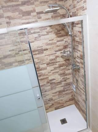 a shower with a glass door in a bathroom at Minimalist Apartment Located near Belém in Lisbon