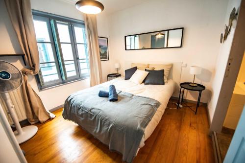 1 dormitorio con cama y ventana grande en Duplex Typique Centre Bayonne en Bayonne