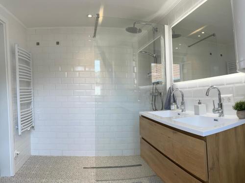 ein weißes Badezimmer mit einem Waschbecken und einem Spiegel in der Unterkunft StylishHomes NEST - A Cosy Adventure in Frauental an der Lassnitz 