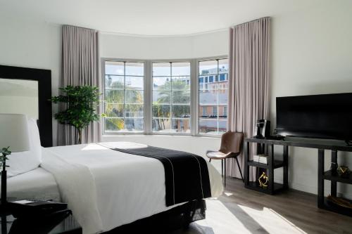 a bedroom with a bed and a large window at Essex House Hotel in Miami Beach