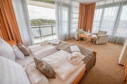 a bedroom with a large bed with towels on it at Szent János Hotel in Mohács