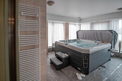 a bathroom with a jacuzzi tub in a room at Szent János Hotel in Mohács