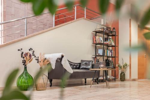 a living room with a couch and a staircase at Szent János Hotel in Mohács