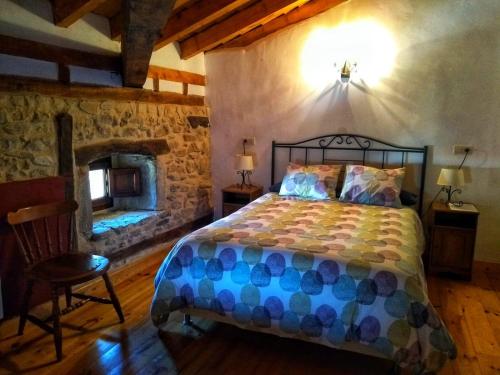 a bedroom with a bed and a stone wall at Don Baldomero Hotel Rural in Cadiñanos