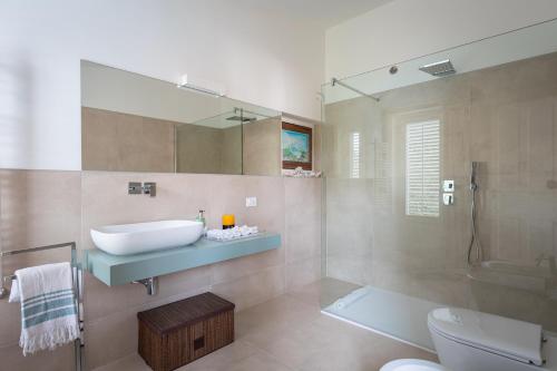 a bathroom with a sink and a toilet and a mirror at Domus Orestea Luxury Suites in Palermo