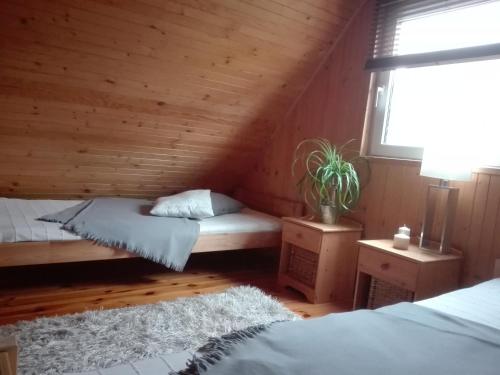 Un dormitorio con dos camas en una cabaña de madera. en Domek Bałtycki Lux, en Rewa