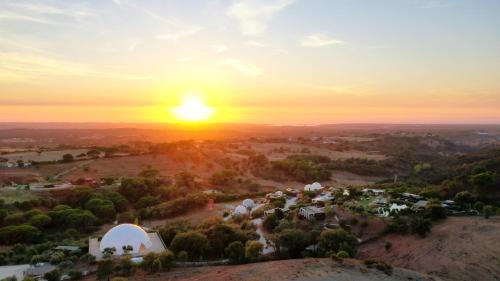 an aerial view of a village at sunset at Reserva Alecrim EcoSuite & Glamping in Santiago do Cacém
