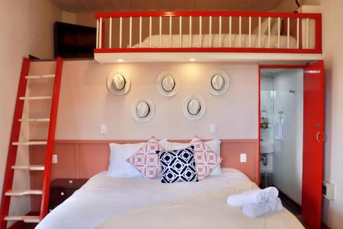 a bedroom with a red bunk bed with pillows at La Cabaña Ecohotel - Valle del Cocora in Salento