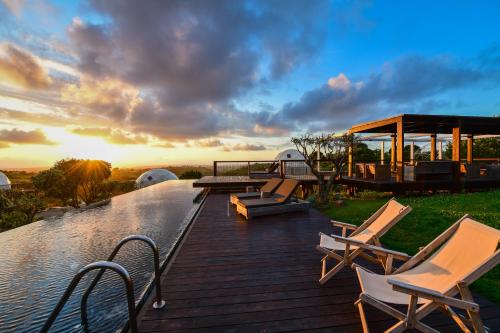 a wooden deck with chairs and a gazebo at wecamp Reserva Alecrim in Santiago do Cacém