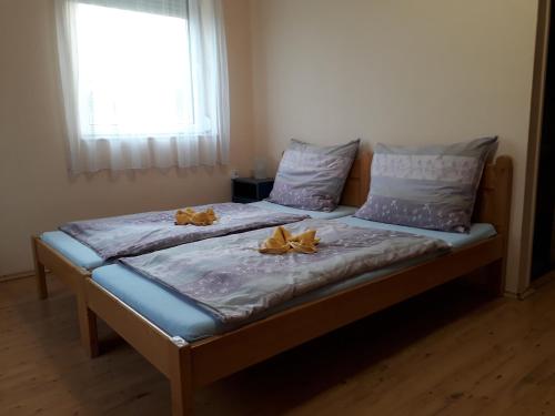 Una cama en una habitación con dos flores amarillas. en Örvény Vendégház en Tiszafüred