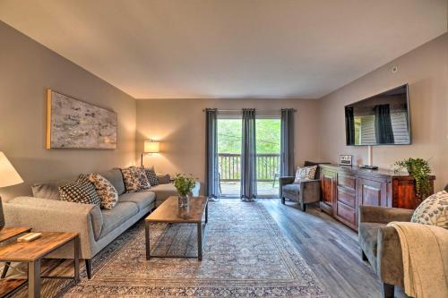 a living room with a couch and a table at Modern Condo with Deck about 7 Mi To Branson Landing! in Branson