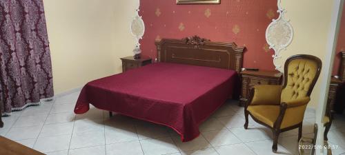 a bedroom with a purple bed and a chair at Casa vacanza Poggio Rotondo in Ravanusa