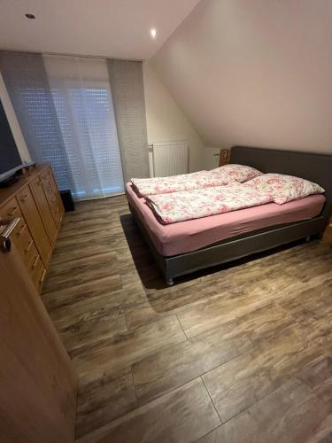 Schlafzimmer mit einem Bett und Holzboden in der Unterkunft Gästezimmer Am Haarhaus in Ostbevern