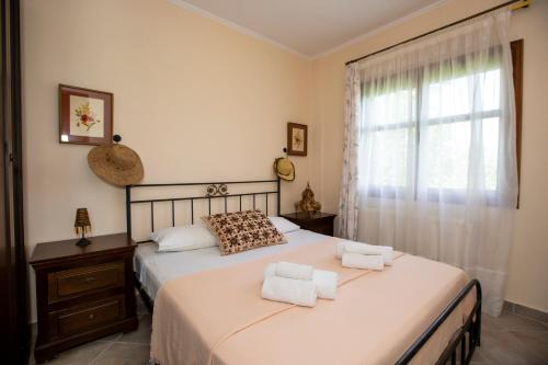een slaapkamer met een bed met twee handdoeken erop bij Traditional beach house in Sozopoli