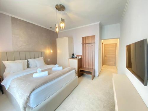 a bedroom with a large bed and a television at CoolKush Boutique in Constanţa