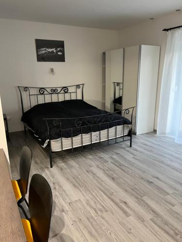 um quarto com uma cama preta num quarto em Stara Jezica Apartments with WiFi em Ljubljana