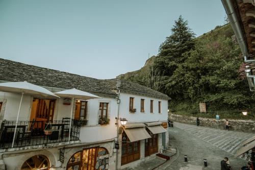 a building on a street with a mountain in the background at Grey Stone in Gjirokastër
