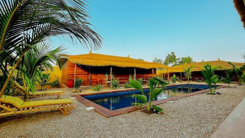 a resort with a swimming pool in front of a building at Le CavaLodge in Ngaparou