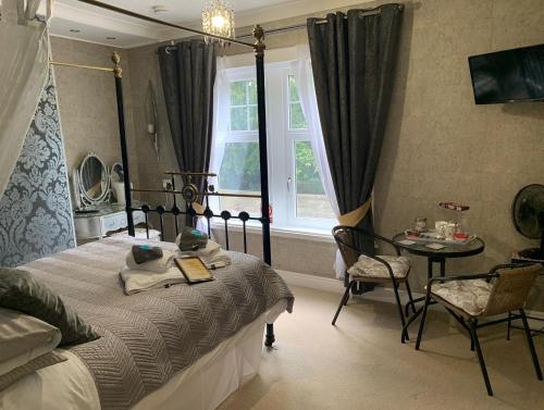 馬特洛克的住宿－Slayleigh B&B, Matlock，一间卧室配有一张床、一张桌子和一个窗户。