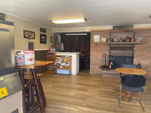 a living room with a fireplace and a table and chairs at Saddle & Surrey Motel in Estes Park