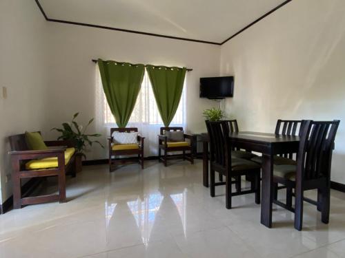 a dining room with a table and chairs and a television at Casa Binisa Fresca y agradable in Liberia