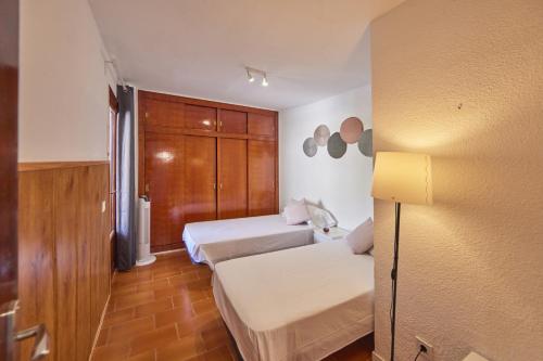 a small room with two beds and a closet at Nura Houses Magaluf Apartment in Magaluf