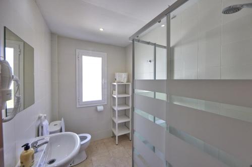 bagno con lavandino e doccia in vetro di Nura Houses Apartment Magaluf 1 a Magaluf