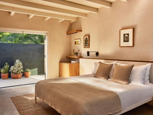 a bedroom with a bed and a large window at Hotel June Malibu in Malibu