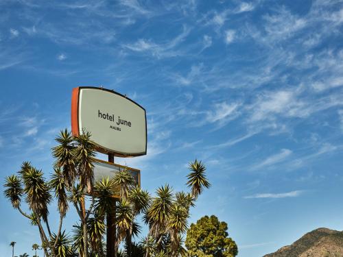 a sign for a hotel with palm trees at Hotel June Malibu in Malibu
