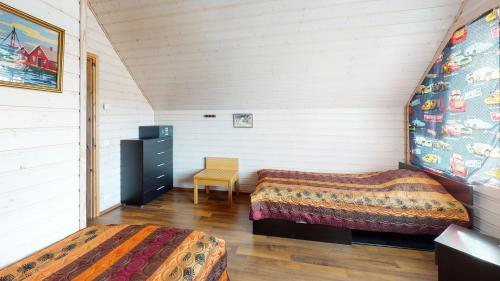 Schlafzimmer im Dachgeschoss mit 2 Betten und einem Stuhl in der Unterkunft Saimaa Marina Garden Apartments in Lappeenranta