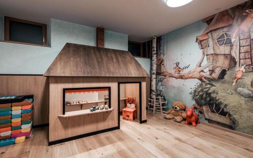 a childs play room with a large wooden dog house at Seehotel Panorama Relax in Resia