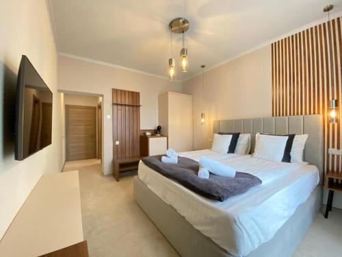 a bedroom with a large bed with blue pillows at CoolKush Boutique in Constanţa