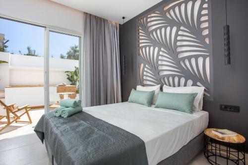 a bedroom with a bed and a large window at Casa Stavris in Faliraki