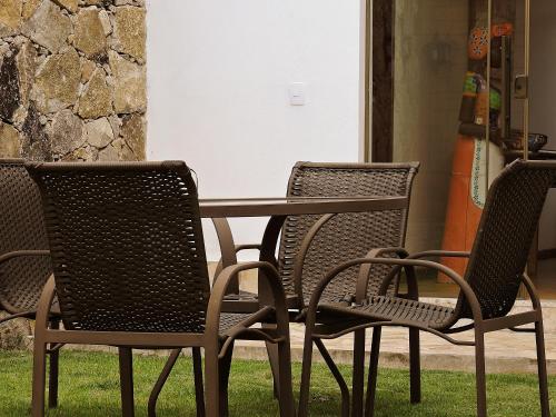 three chairs and a table and a table and chairs at Pousada Ouro de Minas in Tiradentes