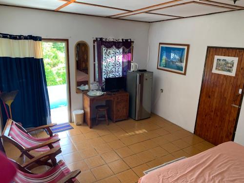 a room with a refrigerator and a table and chairs at Villa Manoir in Anse Lazio