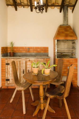 a wooden table and chairs with plants on it at Pousada Ouro de Minas in Tiradentes