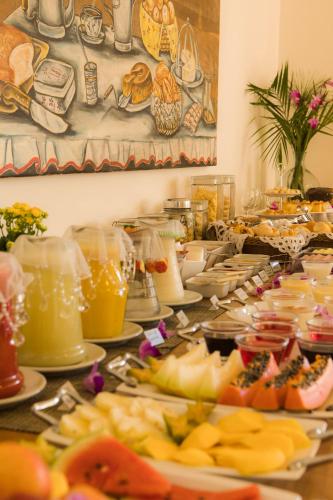 a buffet with many plates of food on a table at Pousada Ouro de Minas in Tiradentes